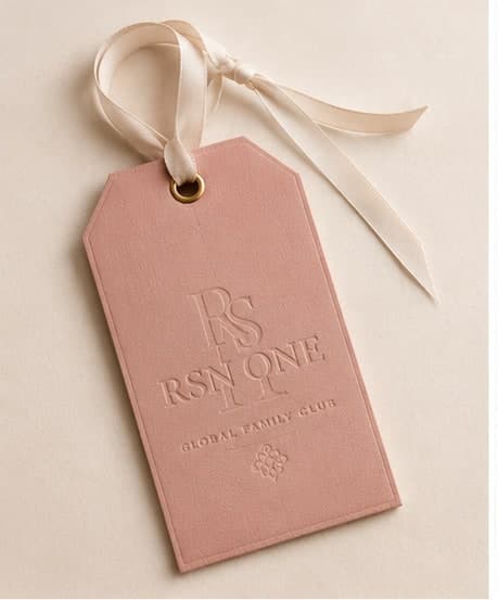 A blush leather RSN ONE tag — pricing direct from the house.